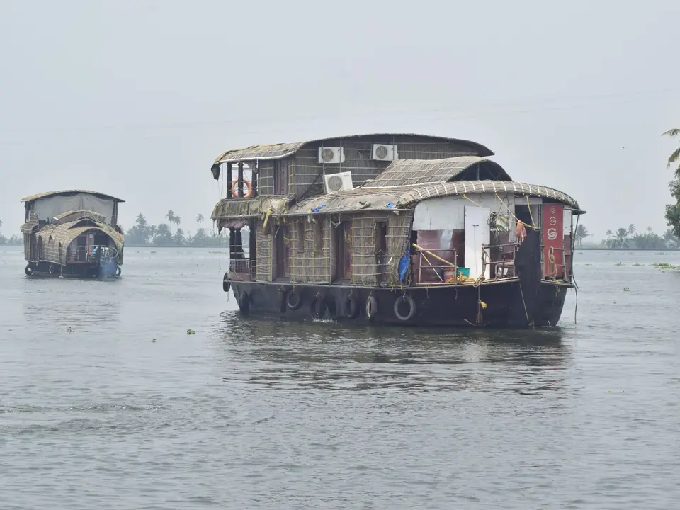 Traditional houseboats cruise the serene backwaters of Alappuzha, Kerala, India