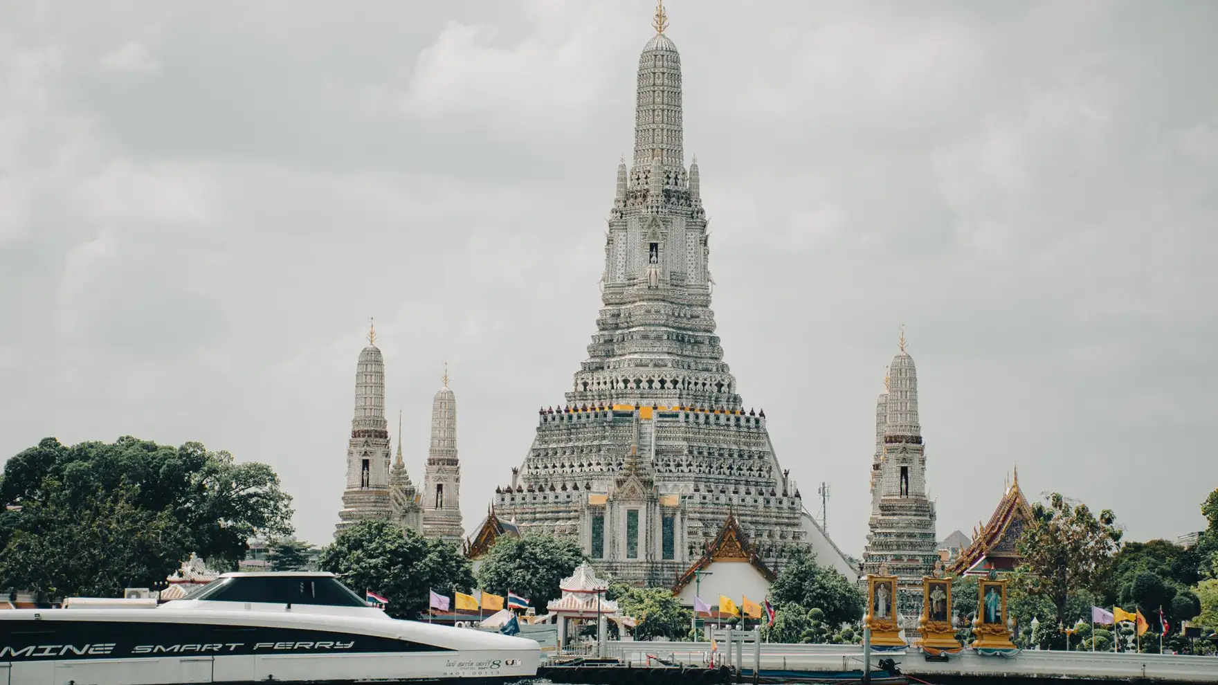Stunning view of Wat Arun temple and Chao Phraya River in Bangkok, Thailand with a ferry boat