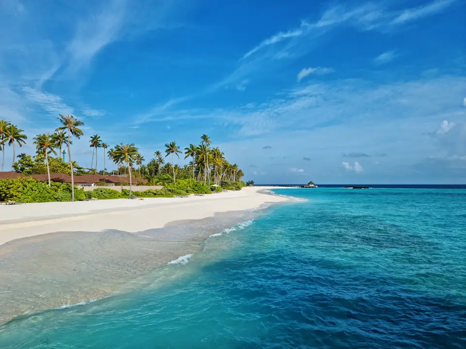 Experience the serene beauty of Maldives with turquoise waters and white sandy beach under a clear blue sky