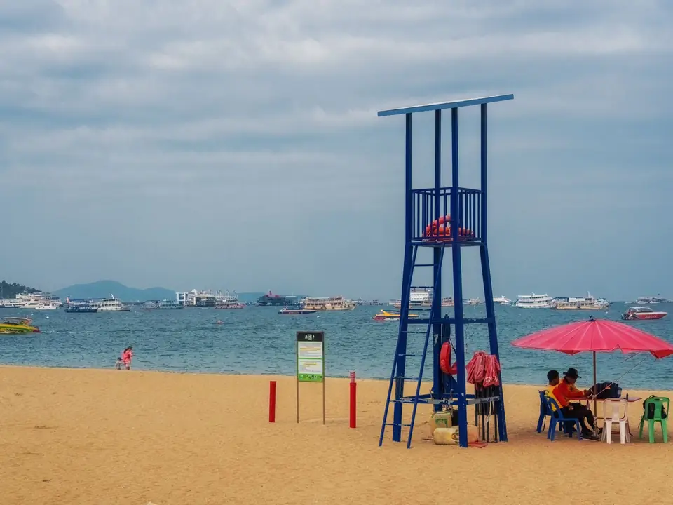 Relaxing scene at Pattaya Beach, Thailand with lifeguard tower and sun umbrellas