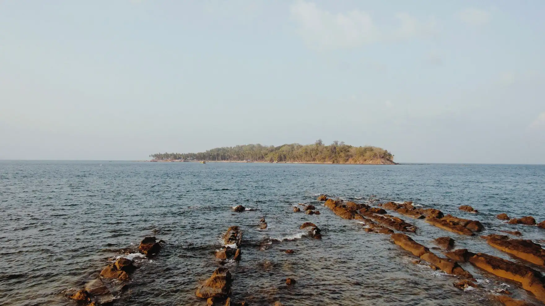 Tranquil ocean view with rocky shoreline and island in Port Blair, India