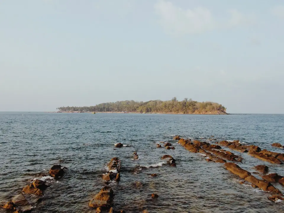 Tranquil ocean view with rocky shoreline and island in Port Blair, India