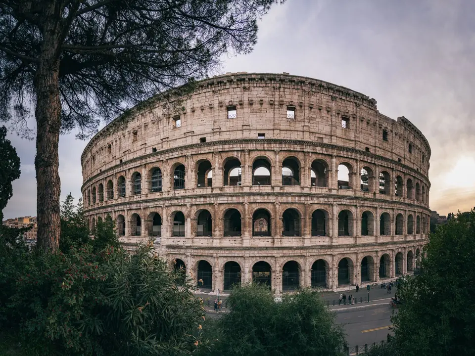 Captivating wide-angle shot of Rome's iconic Colosseum with a serene sunset backdrop