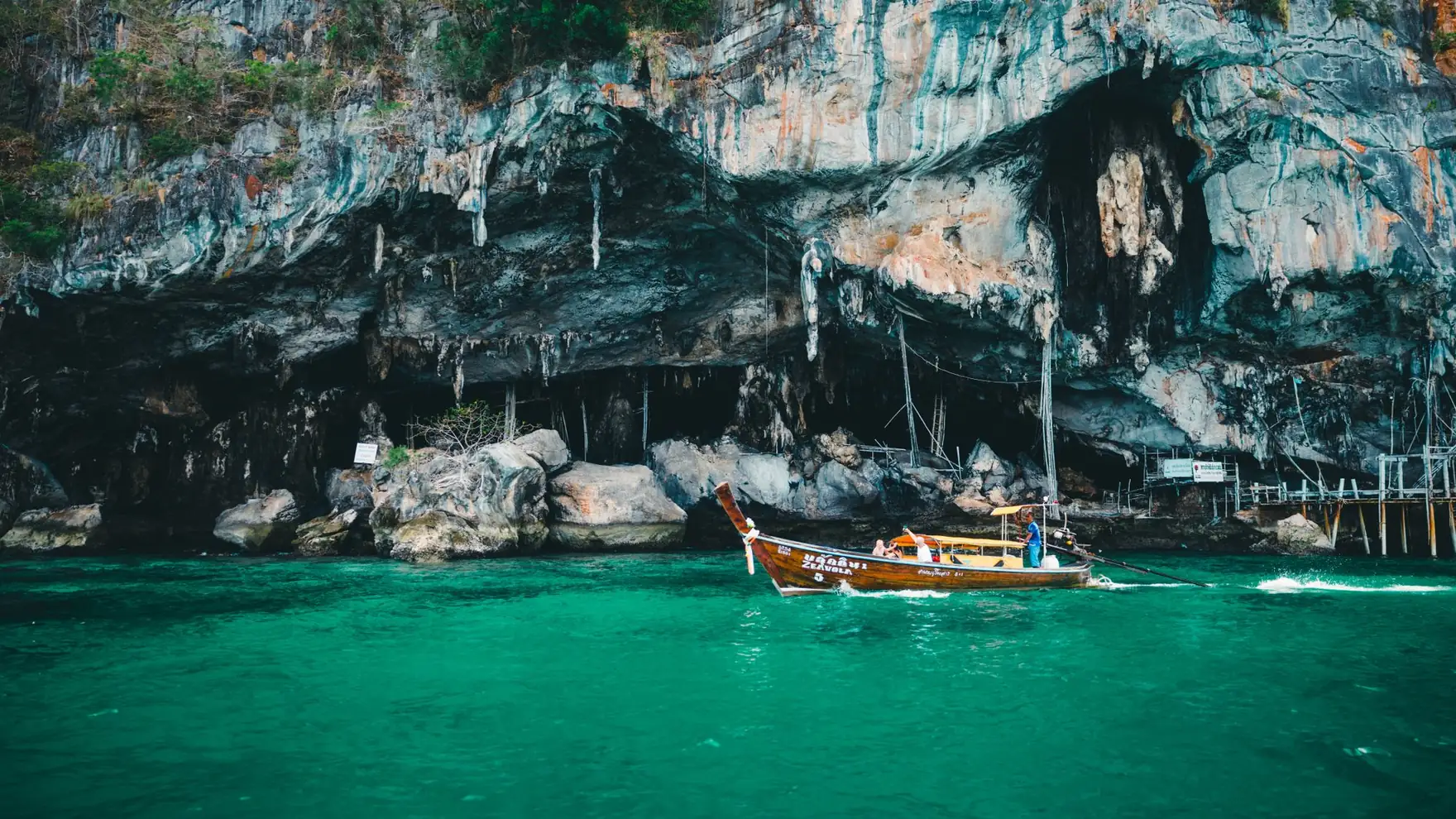 Explore the stunning limestone cliffs of Phuket with a traditional longtail boat on emerald waters
