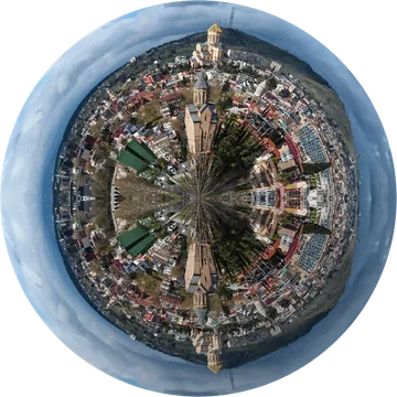 A panoramic view of Tbilisi, Georgia featuring historic churches and diverse architecture under a dramatic sky